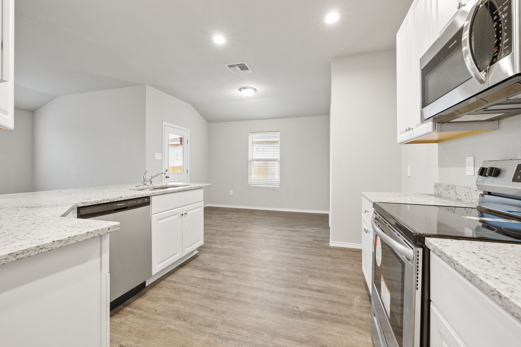 3209 Ridge Place Seguin, TX 78155 - Photo 4 of 23 Kitchen featuring stainless steel appliances, white cabinets, light stone countertops, light wood-style floors, and recessed lighting