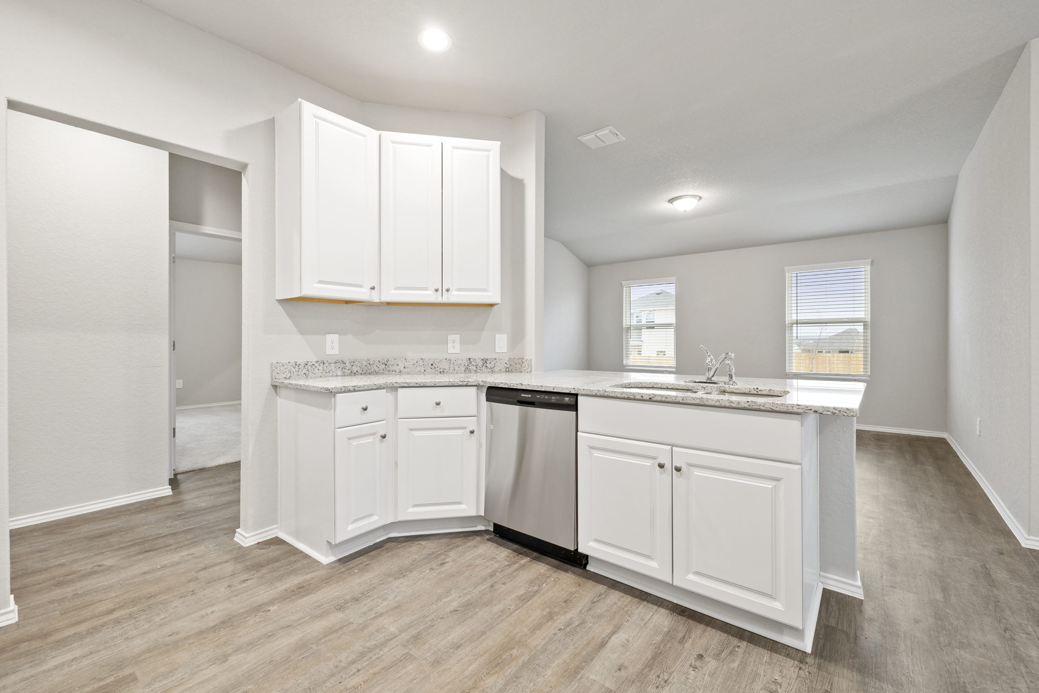 3209 Ridge Place Seguin, TX 78155 - Photo 5 of 23 Kitchen featuring a peninsula, stainless steel dishwasher, light stone countertops, and white cabinets