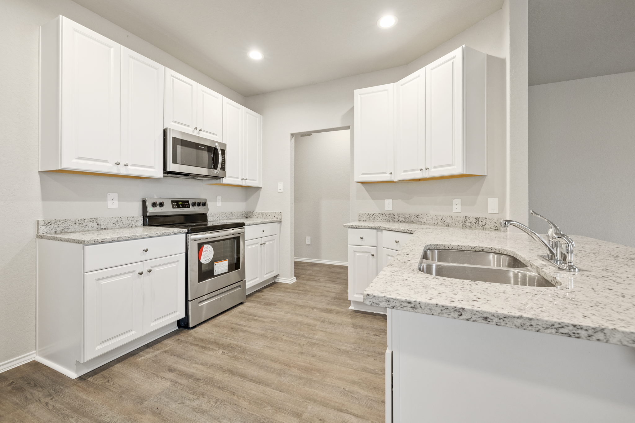 3209 Ridge Place Seguin, TX 78155 - Photo 6 of 23 Kitchen featuring stainless steel appliances, light stone counters, white cabinets, light wood-style flooring, and recessed lighting
