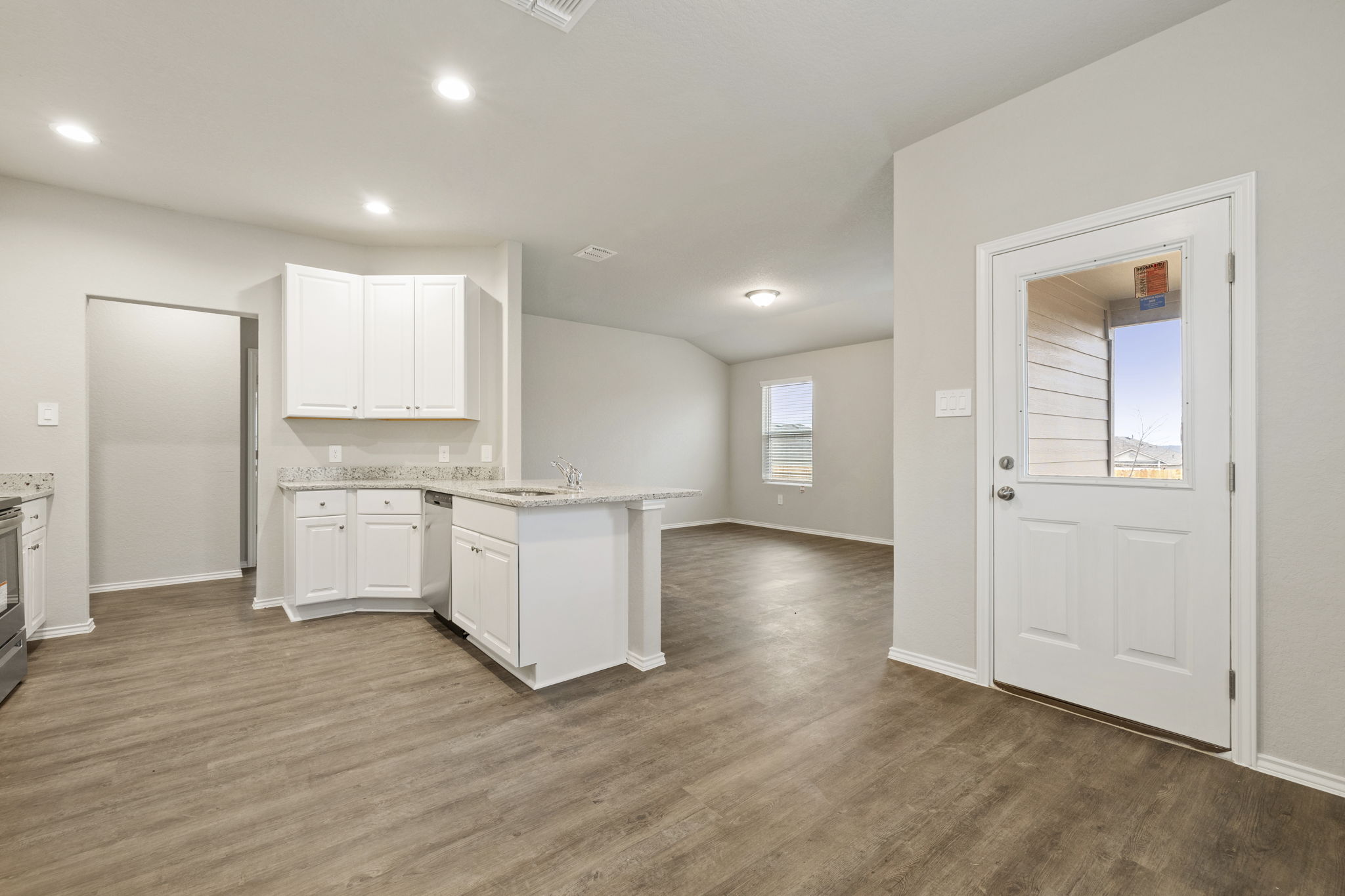 3209 Ridge Place Seguin, TX 78155 - Photo 8 of 23 Kitchen featuring a peninsula, dark wood-style floors, white cabinetry, recessed lighting, and light stone countertops