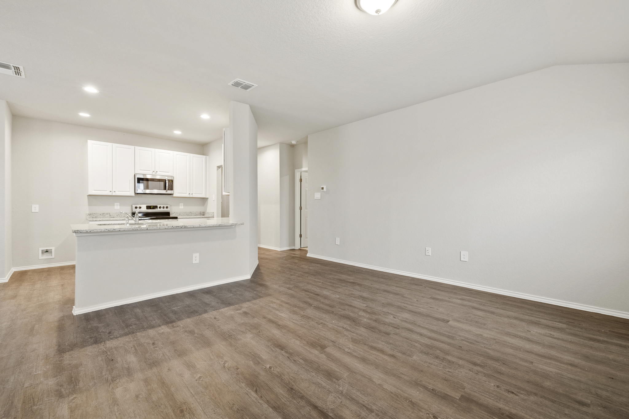 3209 Ridge Place Seguin, TX 78155 - Photo 23 of 23 Kitchen featuring white cabinets, open floor plan, stainless steel microwave, dark wood-style flooring, and white electric range oven