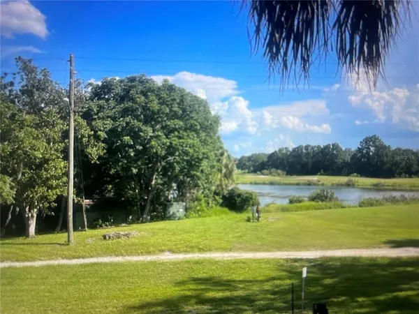 a view of a fountain in front of a house with a big yard