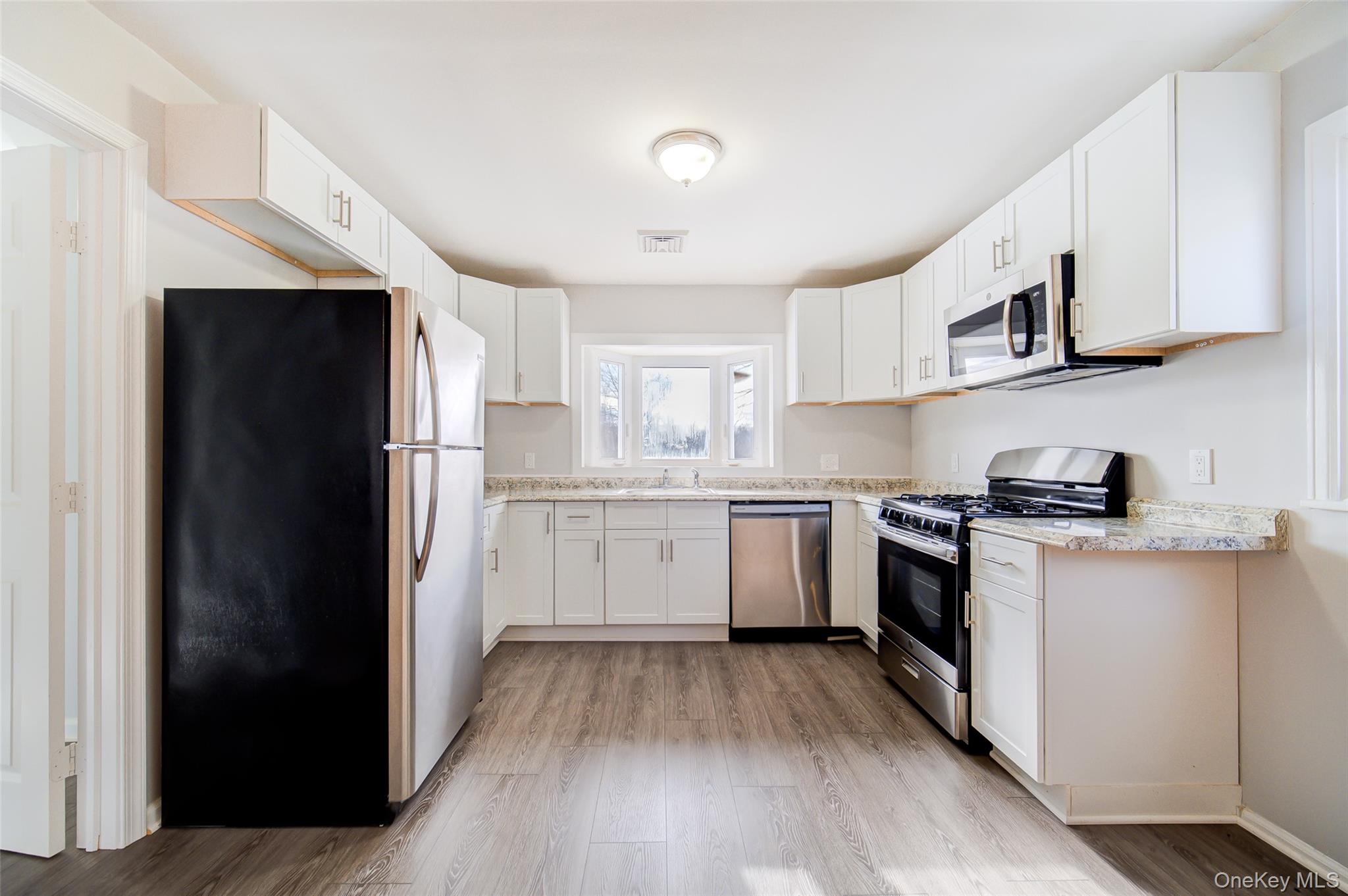 2213 Mt Hope Road, Unit A Middletown, NY 10940 - Photo 12 of 21 a kitchen with white cabinets and stainless steel appliances