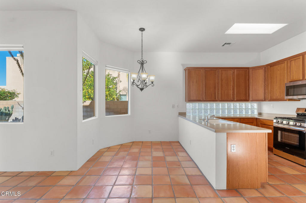 67 Tempe Trail Palm Desert, CA 92211 - Photo 14 of 56 a kitchen with stainless steel appliances granite countertop a sink a stove top oven a counter space and cabinets