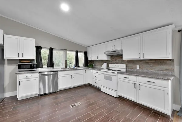 a kitchen with granite countertop white cabinets and white appliances
