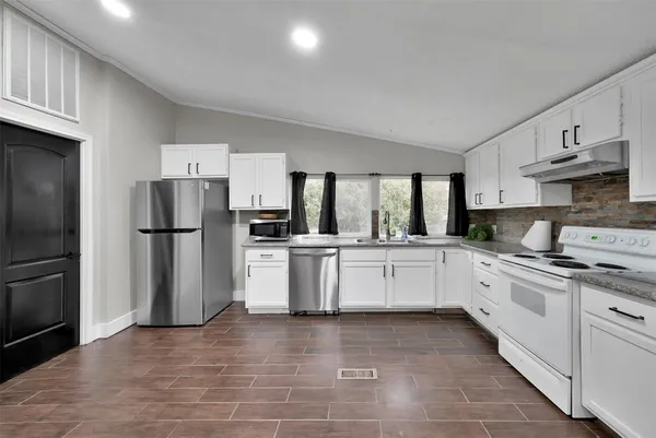 a kitchen with a refrigerator and a stove