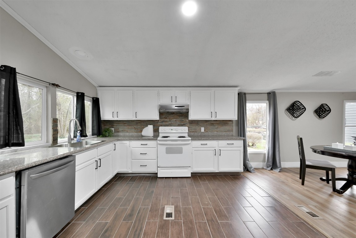 22603 Tuwa Road Tomball, TX 77375 - Photo 18 of 39 a kitchen with stainless steel appliances white cabinets and wooden floors