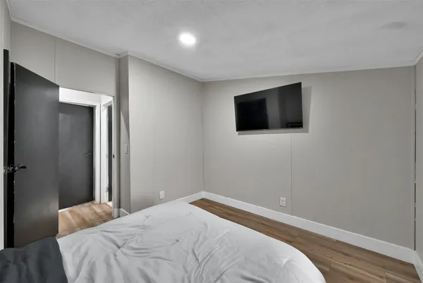 a bedroom with a bed and a flat screen tv