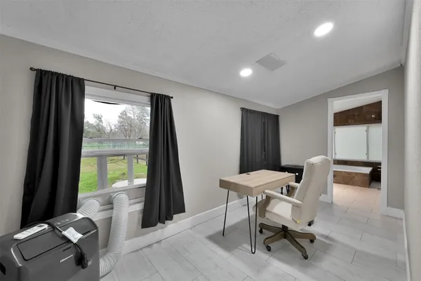a view of a workspace with furniture and a window