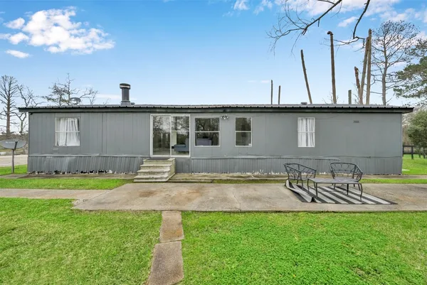 a view of a house with backyard and sitting area