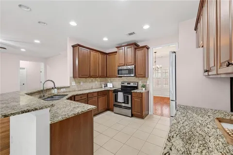 a kitchen with stainless steel appliances granite countertop a sink stove and refrigerator