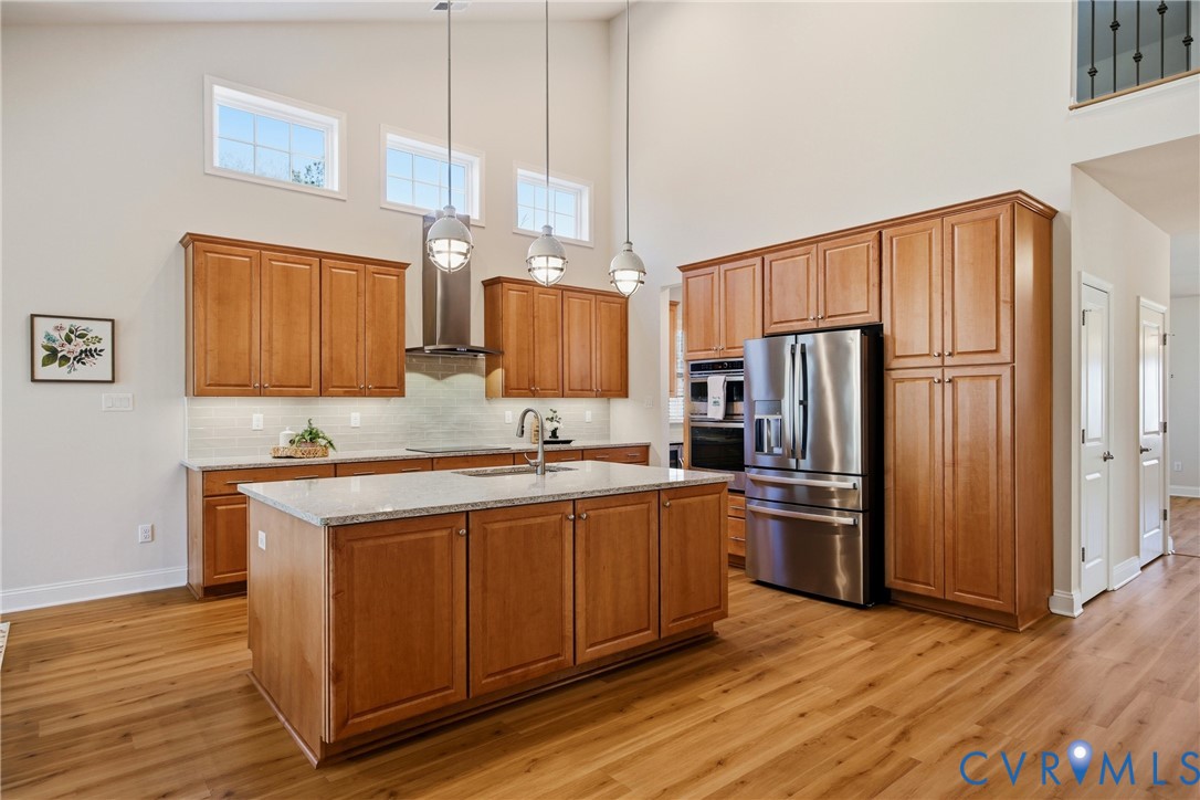 6101 Courage Trail Chester, VA 23831 - Photo 16 of 50 a kitchen with stainless steel appliances granite countertop a refrigerator a sink dishwasher and wooden cabinets with wooden floor