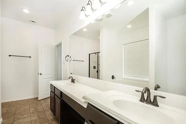 a bathroom with a double vanity sink a mirror and shower