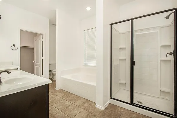 a bathroom with a tub shower and sink