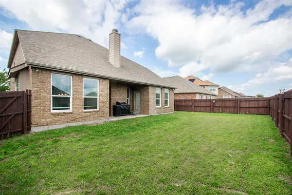 a view of a house with brick walls and a yard with windows