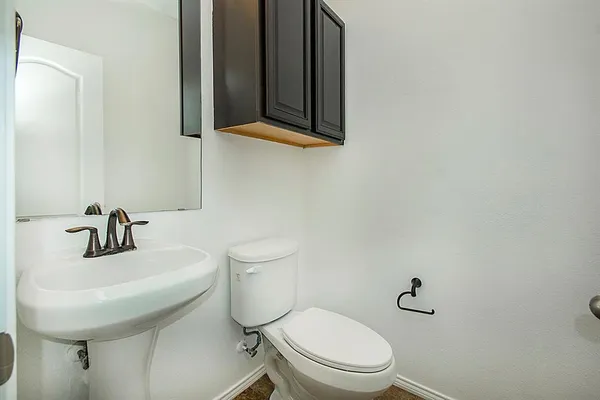 a bathroom with a toilet a sink and mirror