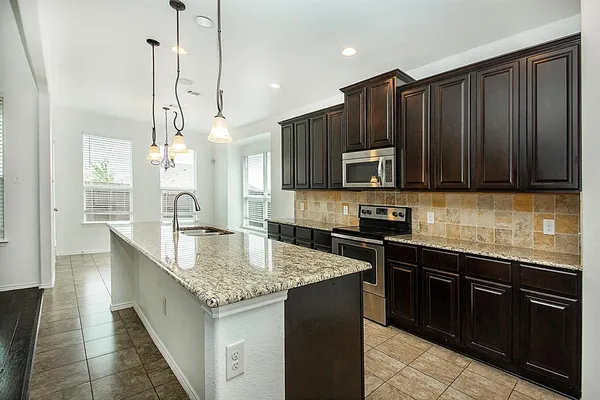 a kitchen with granite countertop stainless steel appliances and wooden cabinets