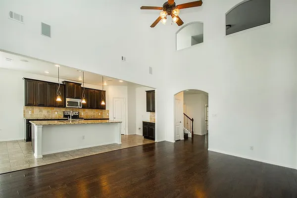 a view of a kitchen with a flat screen tv and wooden floor
