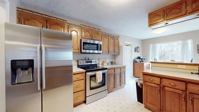 a kitchen with stainless steel appliances granite countertop a refrigerator a stove top oven a sink and dishwasher