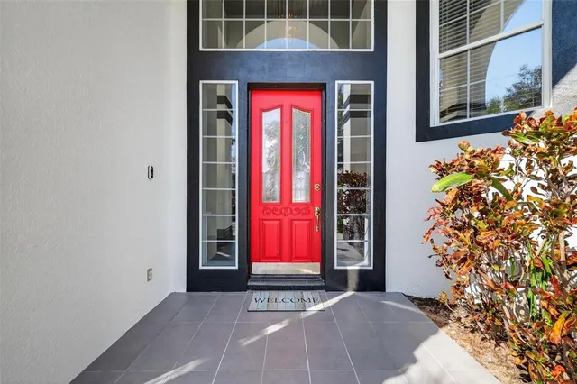 a view of a brick house with a red door and a potted plant