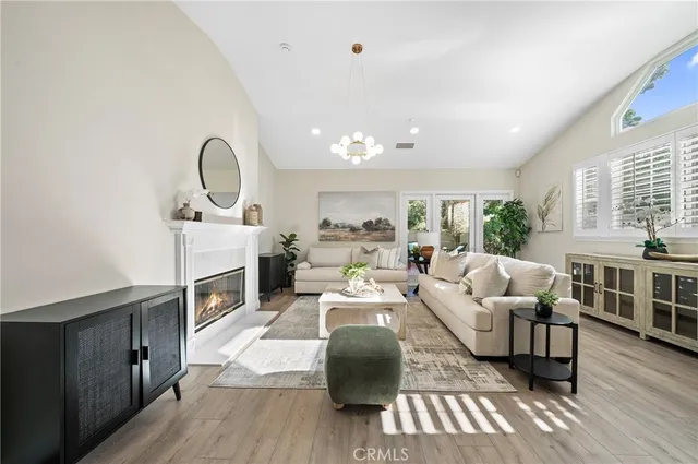 a living room with furniture a fireplace and a floor to ceiling window