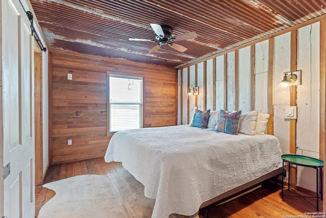 a bedroom with a bed and a dresser next to a window