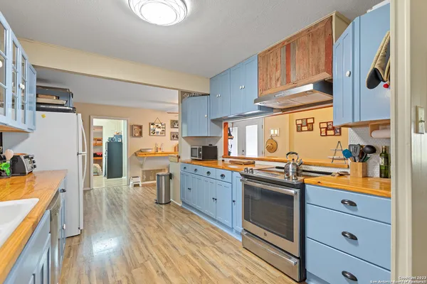 a kitchen with stainless steel appliances granite countertop a lot of counter space and wooden floors