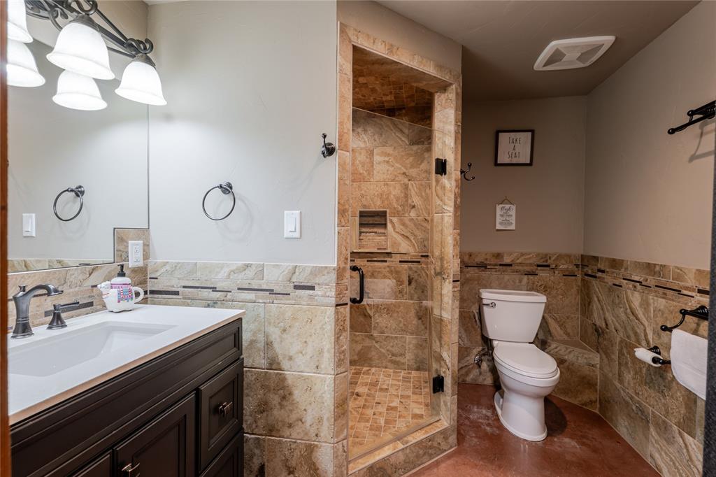 1601 Forum Circle, Unit 156 Graford, TX 76449 - Photo 18 of 28 a bathroom with a granite countertop toilet sink and mirror