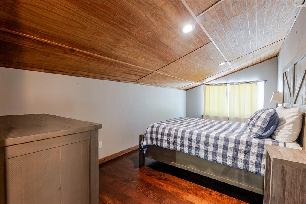 1601 Forum Circle, Unit 156 Graford, TX 76449 - Photo 20 of 28 a bedroom with a bed and wooden floor