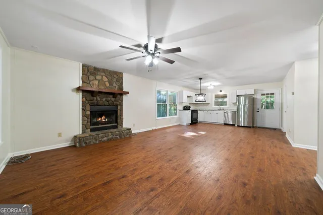 a view of empty room with wooden floor and fireplace