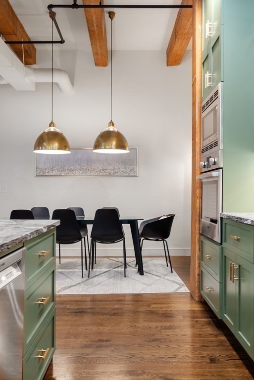 15 Sleeper Street, Unit 302 Boston, MA 02210 - Photo 14 of 35 a kitchen with stainless steel appliances kitchen island a table chairs in it and wooden floor