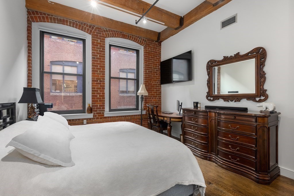 15 Sleeper Street, Unit 302 Boston, MA 02210 - Photo 20 of 35 a bedroom with a bed and wooden floor