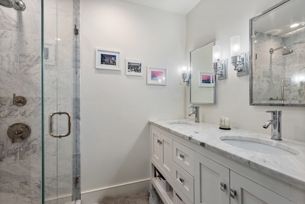 15 Sleeper Street, Unit 302 Boston, MA 02210 - Photo 21 of 35 a bathroom with a granite countertop shower sink and mirror