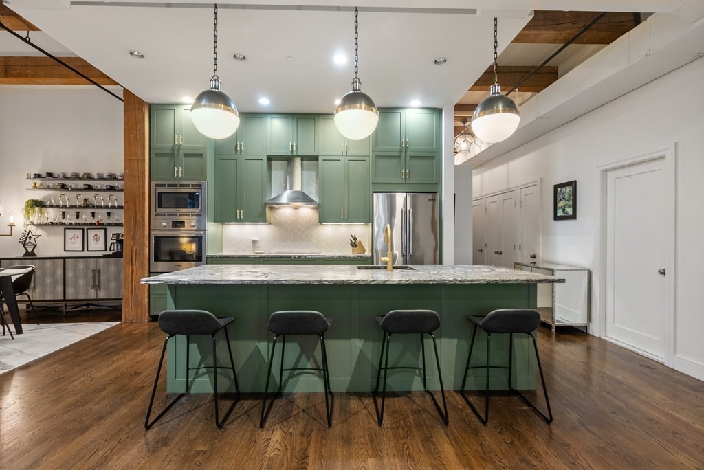 15 Sleeper Street, Unit 302 Boston, MA 02210 - Photo 3 of 35 a kitchen with a table and chairs in wooden floors