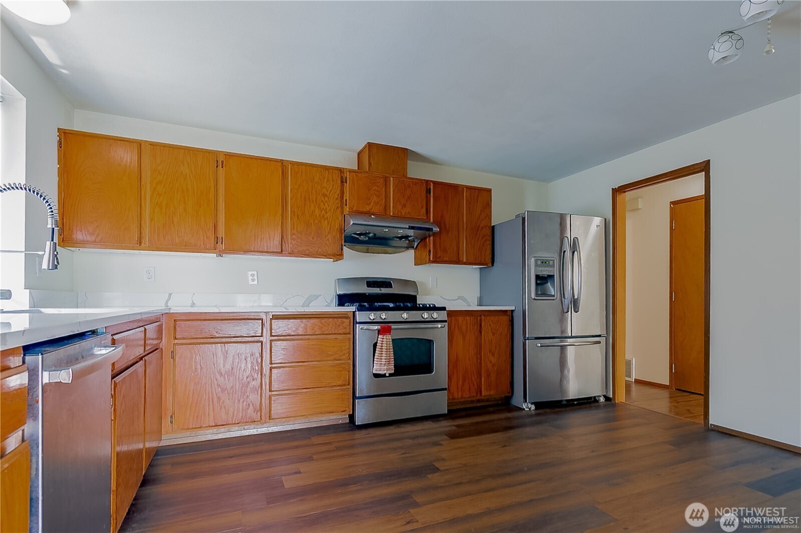 512 North 104th Street Seattle, WA 98133 - Photo 8 of 15 a kitchen with stainless steel appliances granite countertop a stove a refrigerator and a sink with cabinets