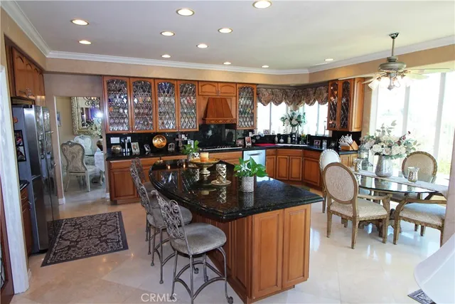 a kitchen with stainless steel appliances granite countertop a table chairs and a chandelier
