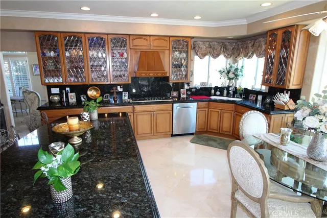 a kitchen with stainless steel appliances granite countertop sink window and chairs