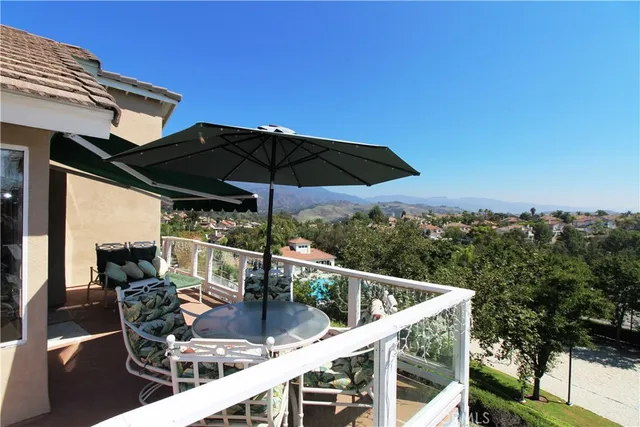 a roof deck with table and chairs under an umbrella