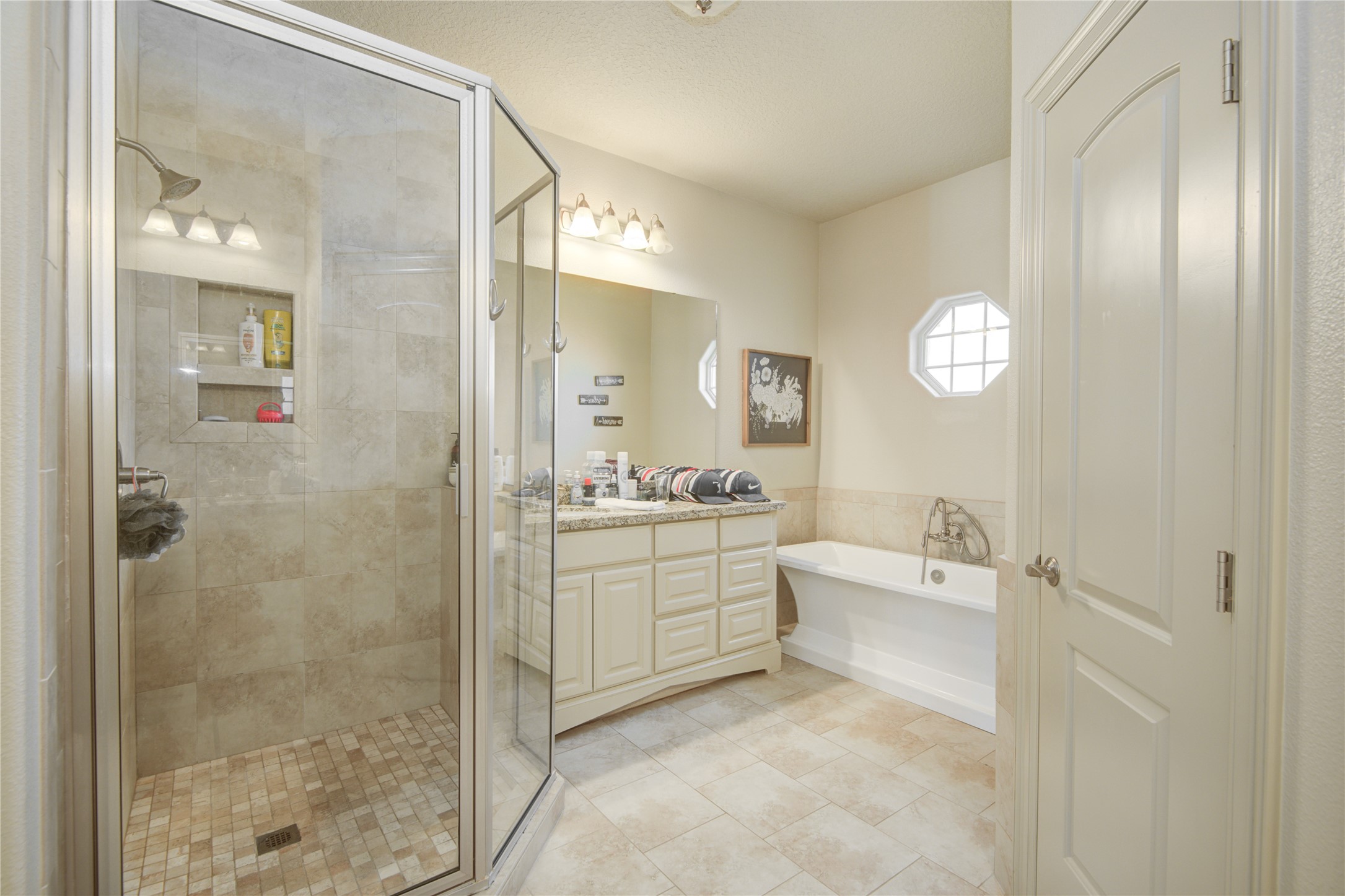 57 Red Maple Court Lake Jackson, TX 77566 - Photo 18 of 44 a spacious bathroom with a granite countertop sink a mirror and a bathtub