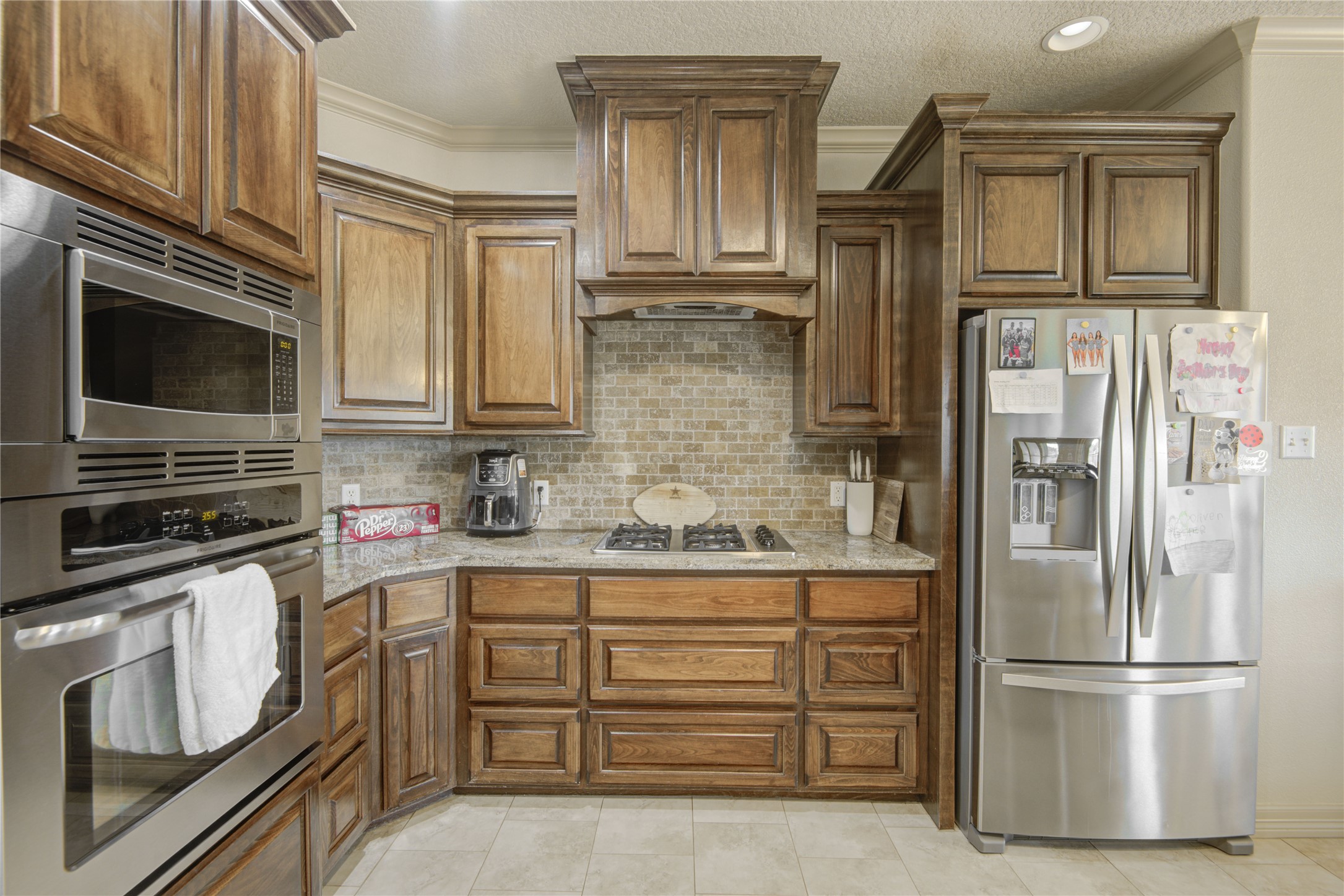 57 Red Maple Court Lake Jackson, TX 77566 - Photo 7 of 44 a kitchen with stainless steel appliances granite countertop a refrigerator and a stove top oven