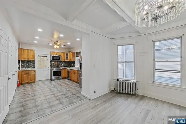 a open kitchen with stainless steel appliances kitchen island granite countertop a refrigerator and stove top oven