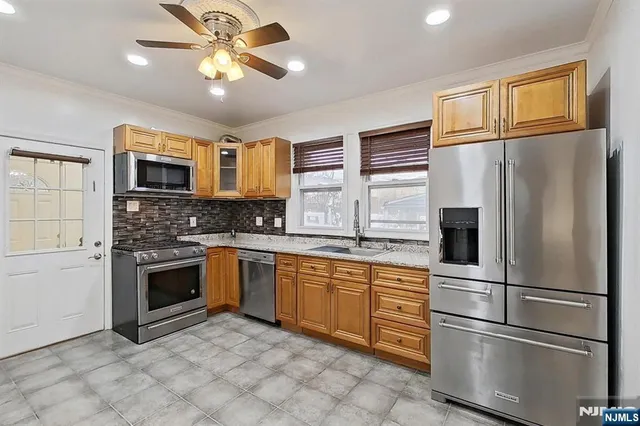 a kitchen with stainless steel appliances granite countertop a refrigerator a stove top oven a sink and dishwasher