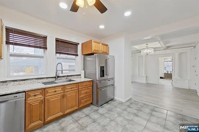 a kitchen with stainless steel appliances granite countertop a refrigerator and a sink