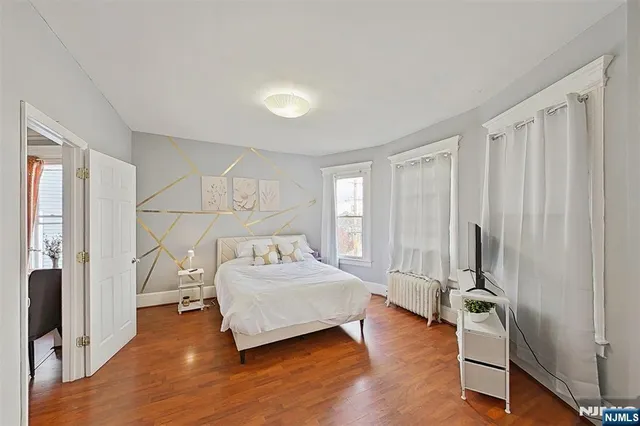 a bedroom with a bed and large windows