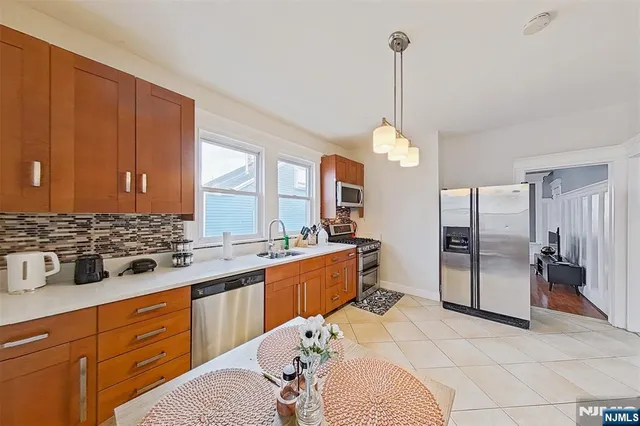 a large kitchen with a window and stainless steel appliances