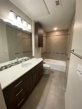 a bathroom with a sink double vanity granite tub shower and a mirror