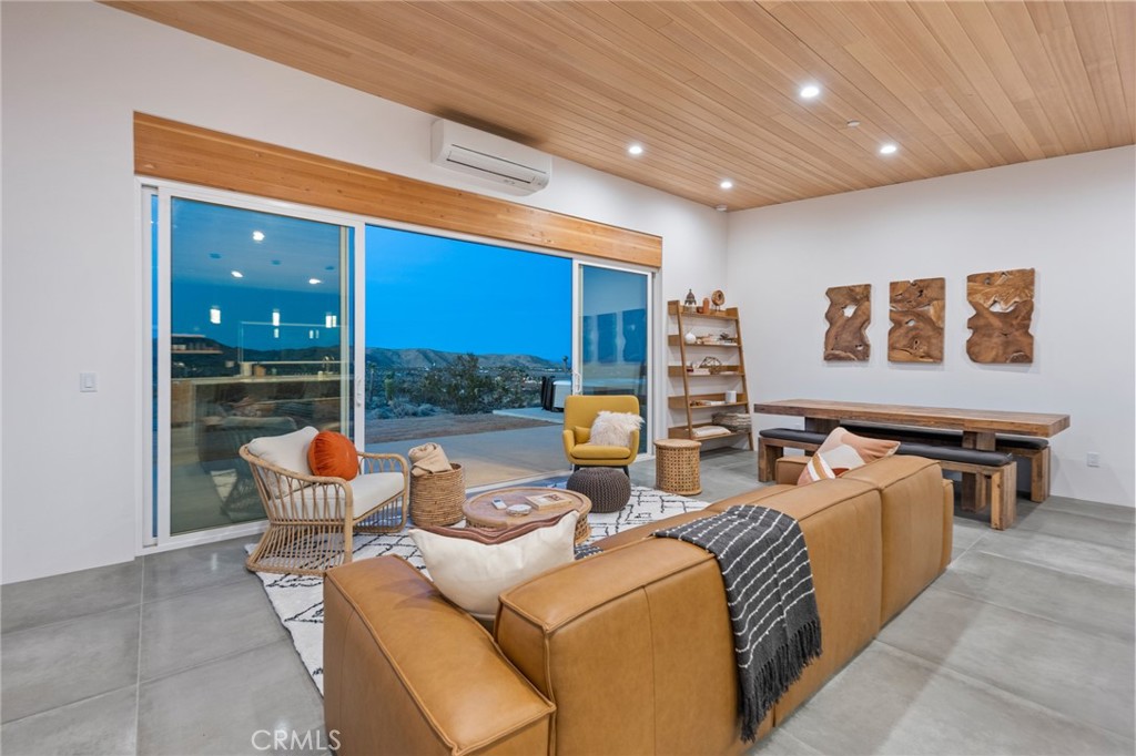 6737 Saddleback Road Joshua Tree, CA 92252 - Photo 14 of 65 a living room with furniture a floor to ceiling window and potted plant