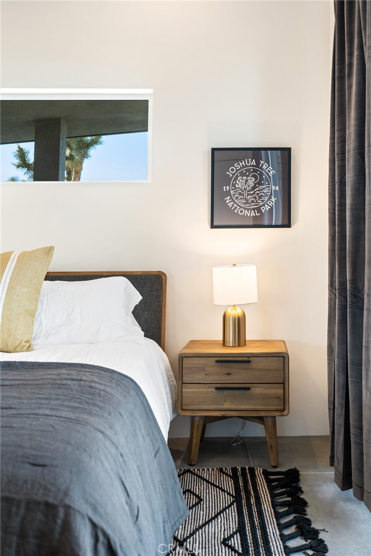 6737 Saddleback Road Joshua Tree, CA 92252 - Photo 21 of 65 a bedroom with a bed and paintings on wall
