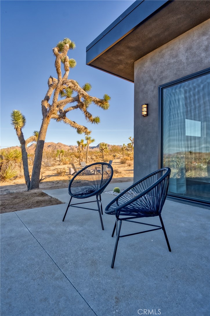 6737 Saddleback Road Joshua Tree, CA 92252 - Photo 39 of 65 a view of a chairs and table in back of the house