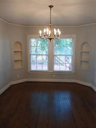 a view of a room with wooden floors and chandelier